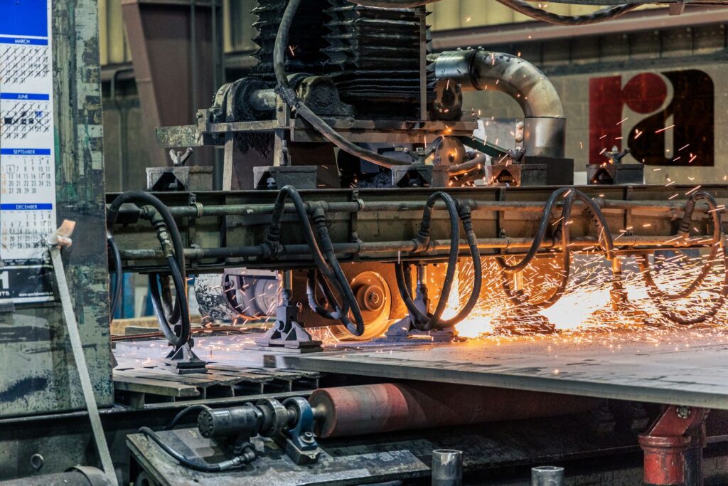 Industriële machine bewerkt metaal met vonken in een fabriekshal