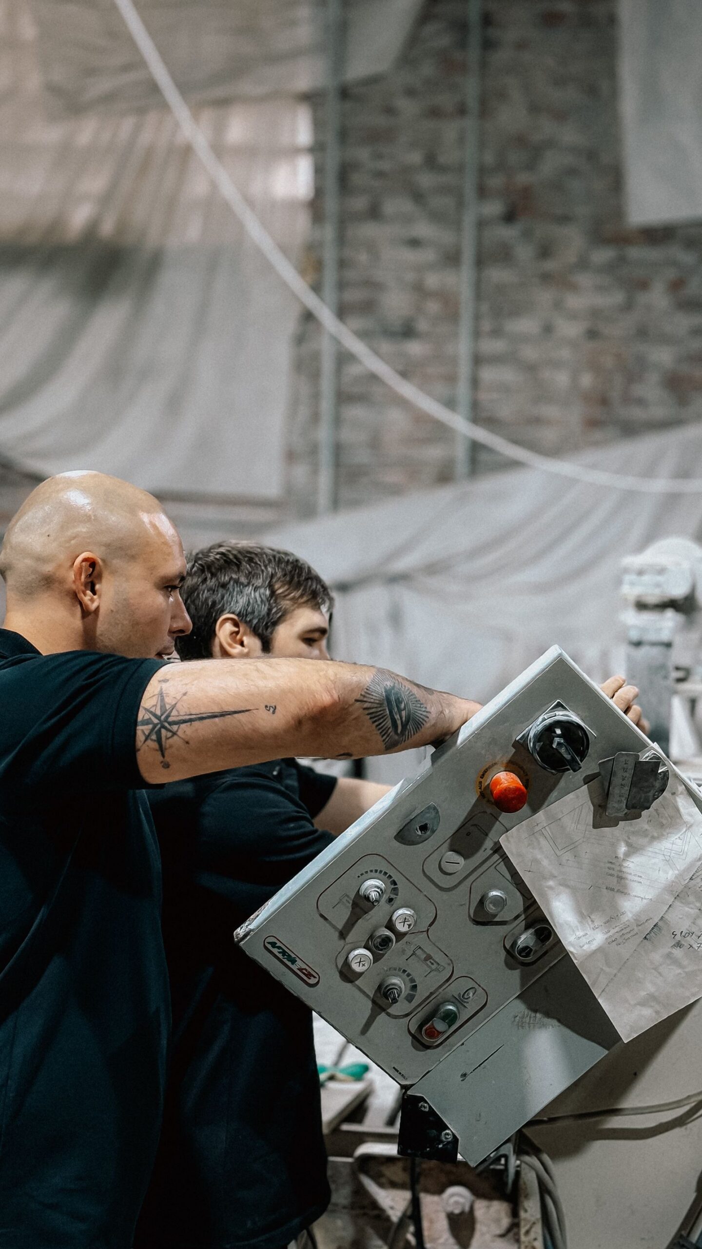 Twee technici bedienen samen een machine in de productiehal