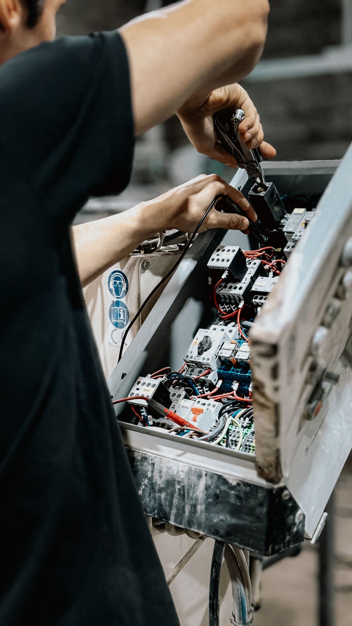 Technicus werkt aan de bekabeling in een elektrische schakelkast