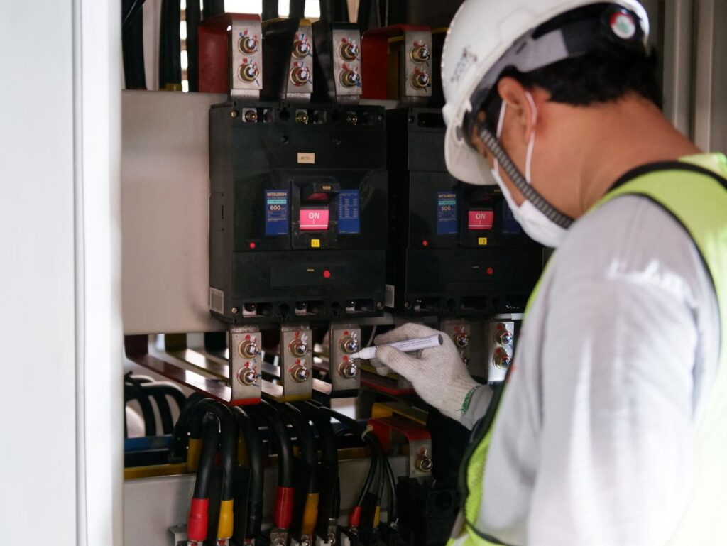 Technicus controleert de spanning van een industriele schakelkast
